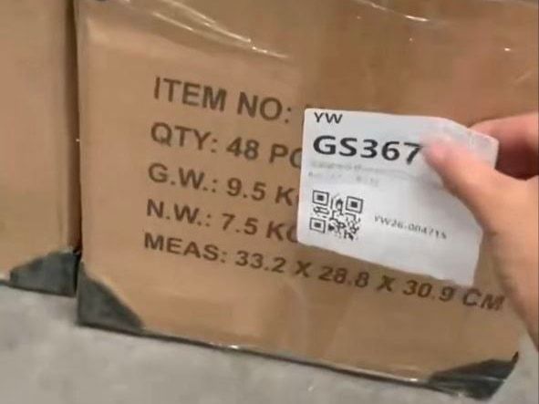 Ivudagi qabul punktida qutiga GS kodli QR stiker yopishtirilmoqda; qutida uning oʻlchami va vazni yozilgan.
